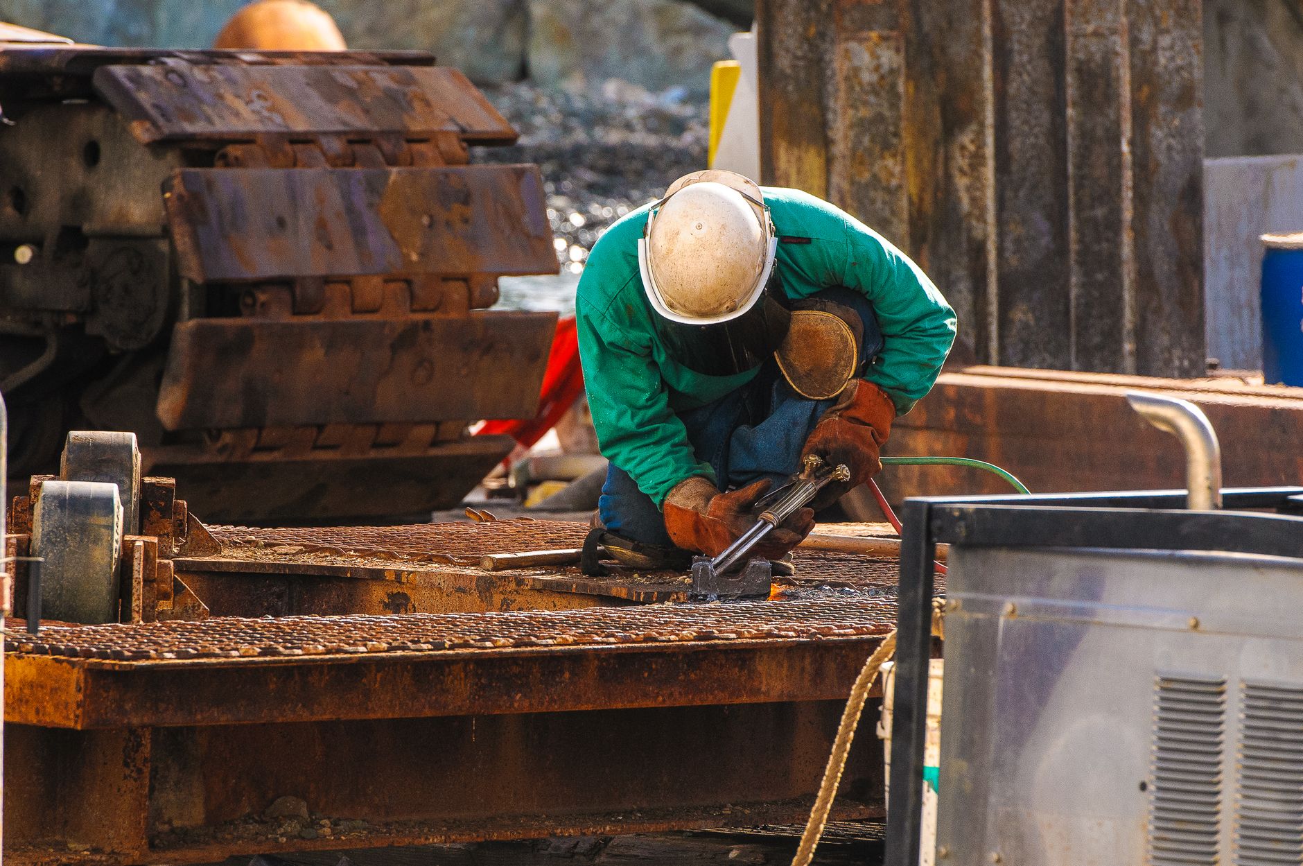 Welder working on structural steel at an industrial facility